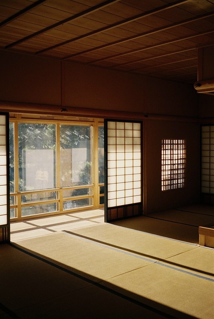 An empty tatami room glowing behind lattice shoji