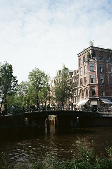 A bridge lined with bikes across an Amsterdam canal