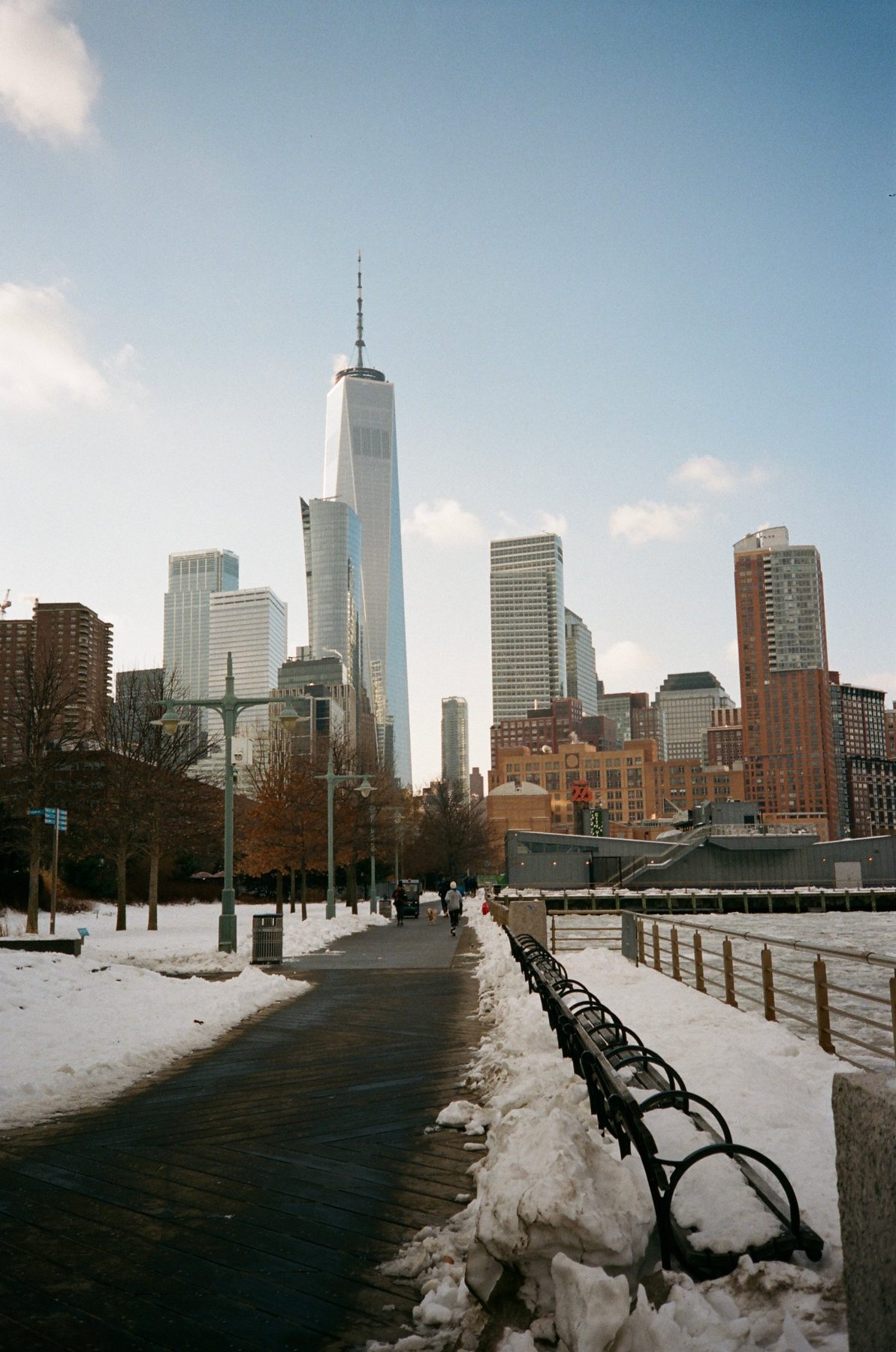 One World Trade Center over a snowy riverside path and empty benches