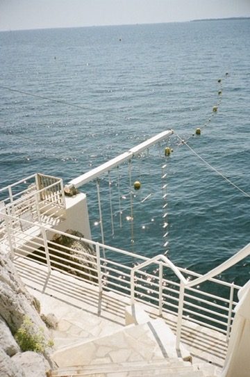 White railings and a sea ladder over glittering water