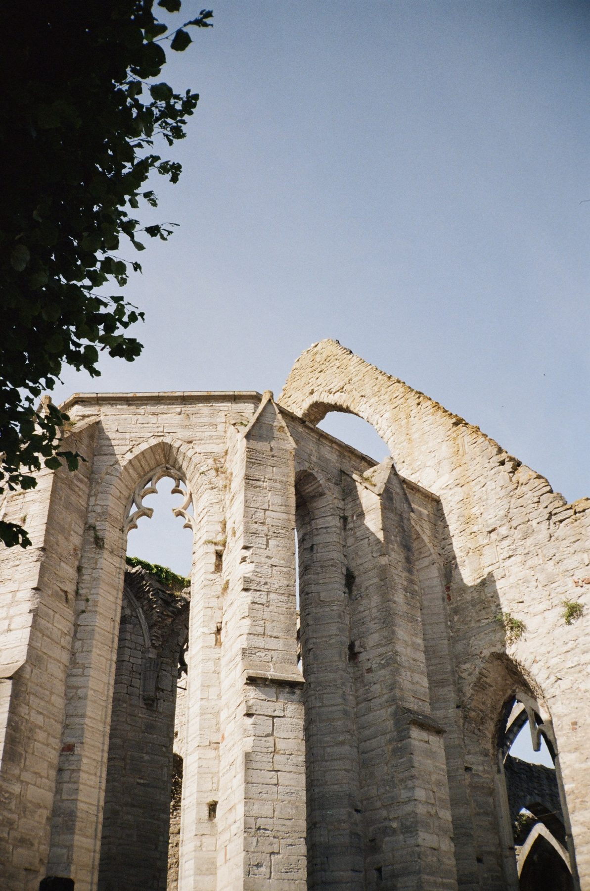 The roofless Gothic arches of a medieval church ruin in Visby against blue sky