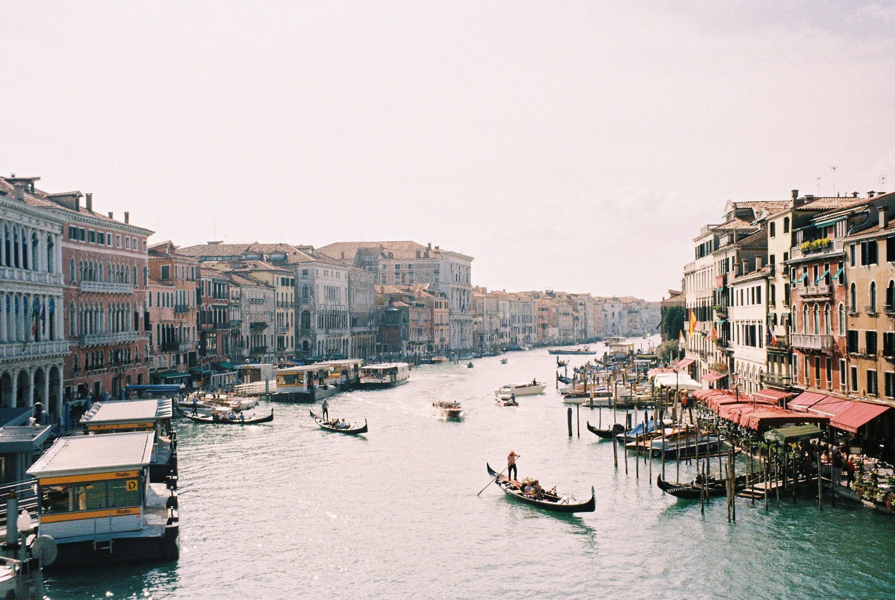 The Grand Canal from the Rialto, gondolas and red awnings under a hazy sky