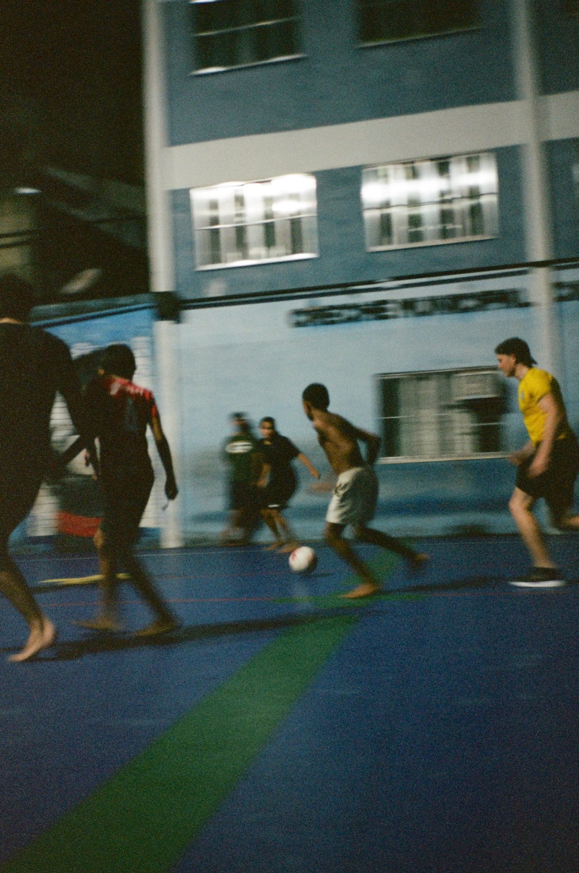 A blurred night football game on a blue court