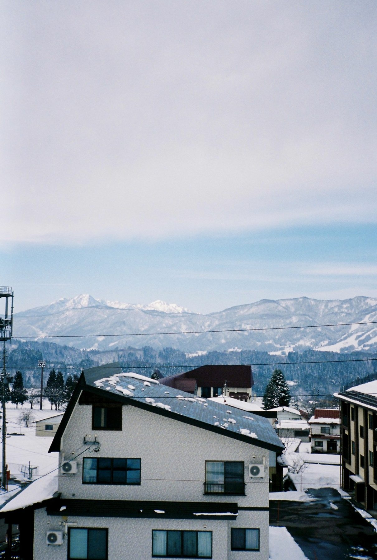 A snowy mountain town below a wide band of winter sky