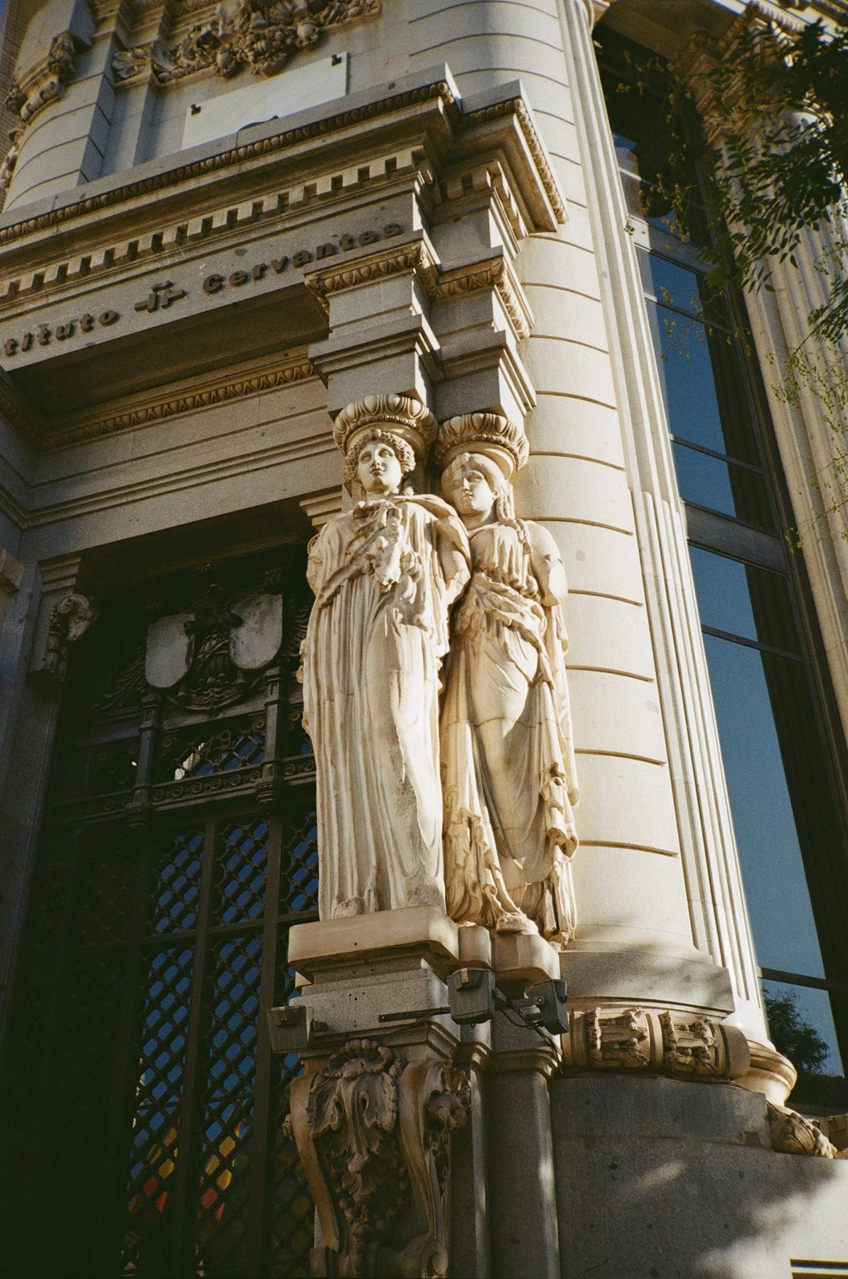 Two carved stone caryatids on the corner of the Instituto Cervantes