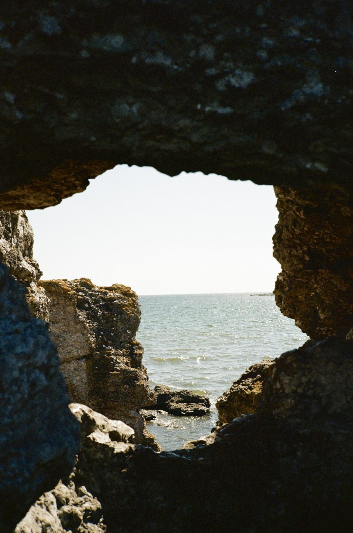 The sea framed through a jagged hole in the rock